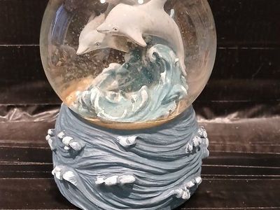A Westland Musical Dolphin Snow Globe with Wave Base - Ocean-themed Decorative Collectible and it plays EBB Tide