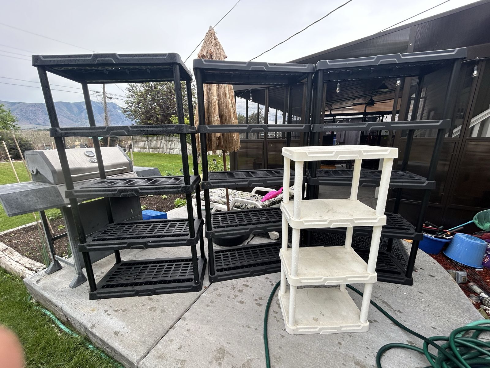 Lot of 4 Plastic Shelves; 3 Black Ones Are 6 Feet Tall by 3 Feet Wide & One is About 5 Feet Tall by 2 Feet Wide