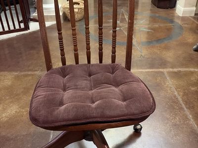 Vintage swivel and wooden brown rolling chair with cushion