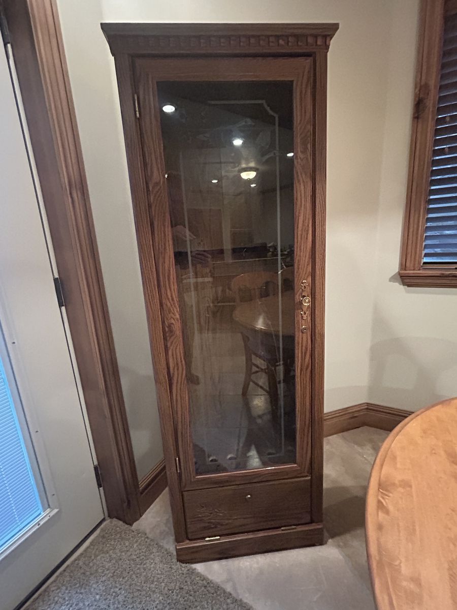 Gun cabinet with locking door and bottom locking shelf.