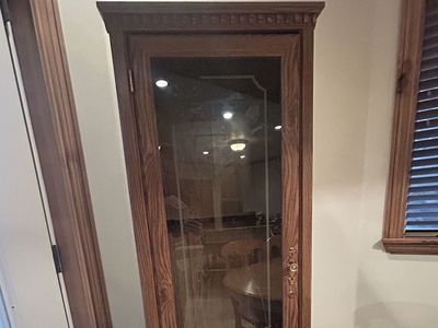 Gun cabinet with locking door and bottom locking shelf.