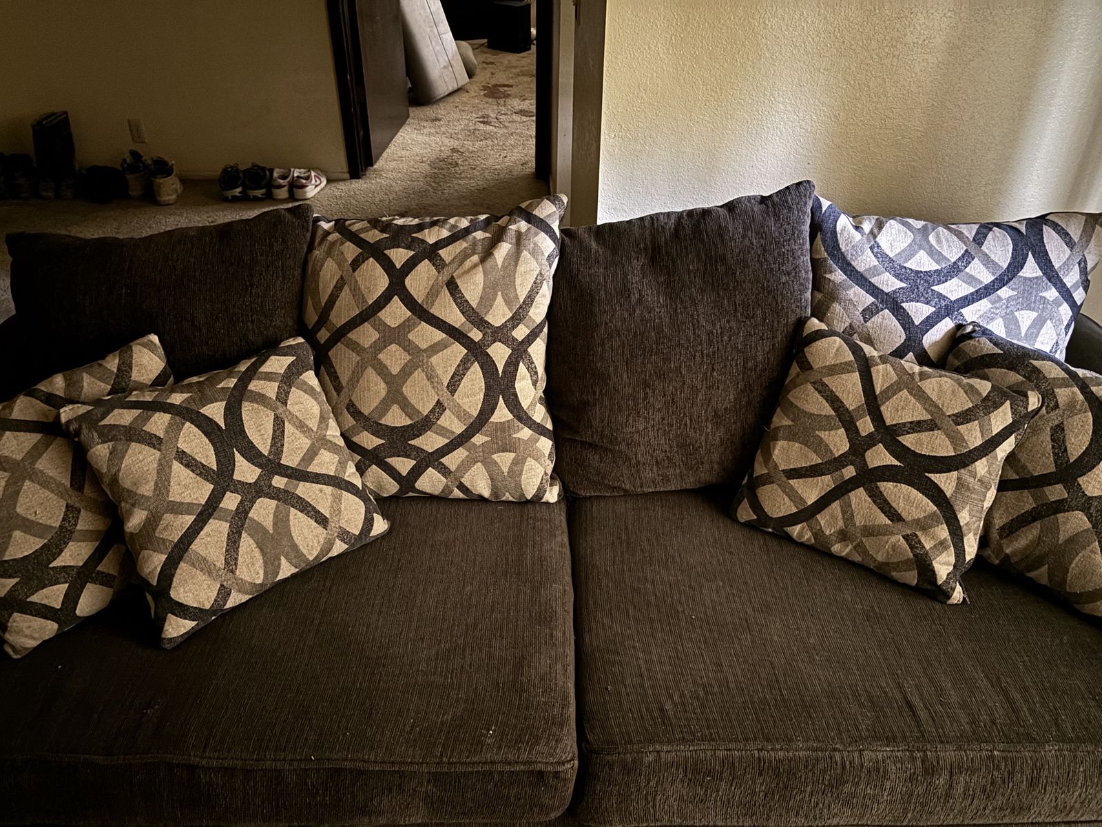 A Dark Grey Fabric Sofa and Loveseat Set with Patterned Accent Pillows