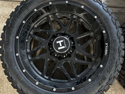 Hostile Black Wheels with Mastertrack Badlands R/T 33x12.50R22LT Tires - Set of 4
