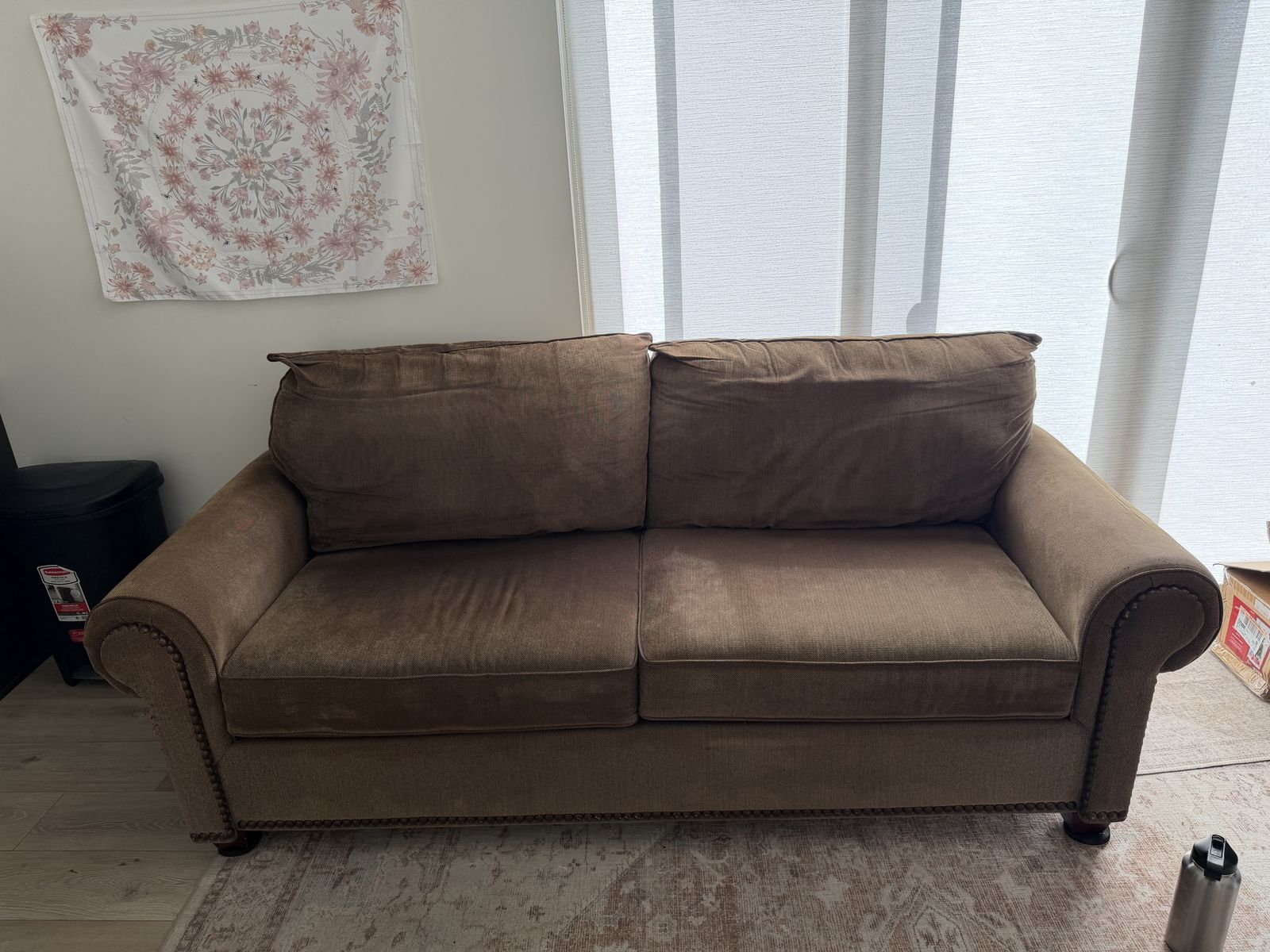 Brown fabric sofa with nailhead trim