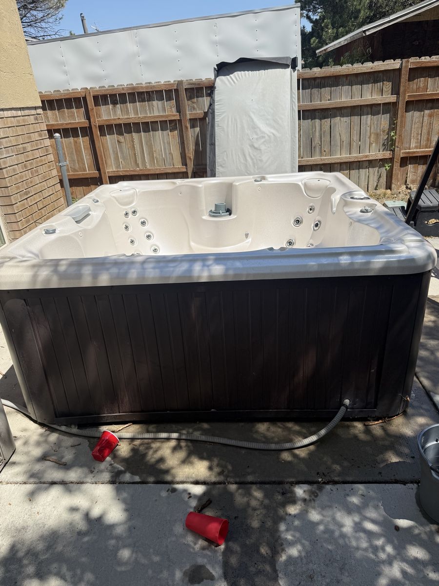 Outdoor Hot Tub / Spa with Dark Wood Siding and Cover