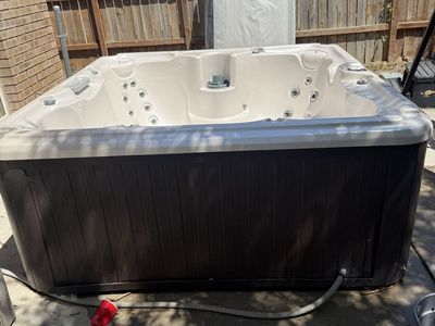 Outdoor Hot Tub / Spa with Dark Wood Siding and Cover