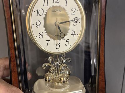 Clock With Rotating Pendulum