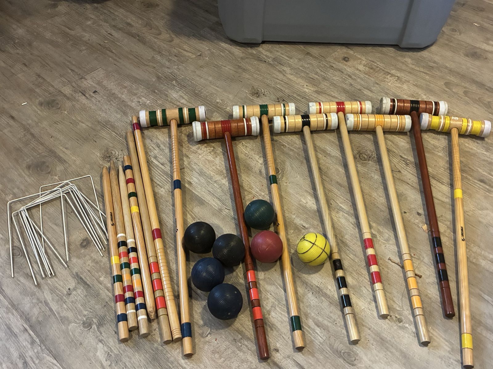 Croquet game mallets, balls and metal stakes.