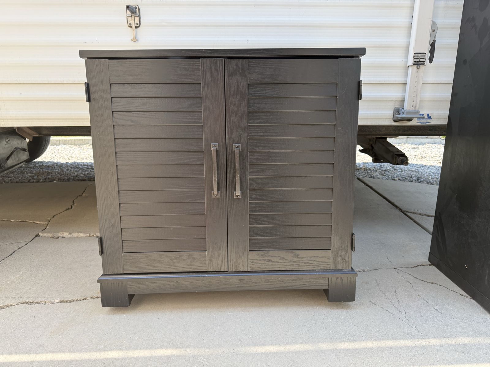 Dark Wood Cabinet with Louvered Doors and Interior Shelf