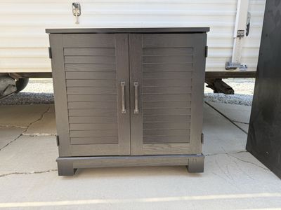 Dark Wood Cabinet with Louvered Doors and Interior Shelf