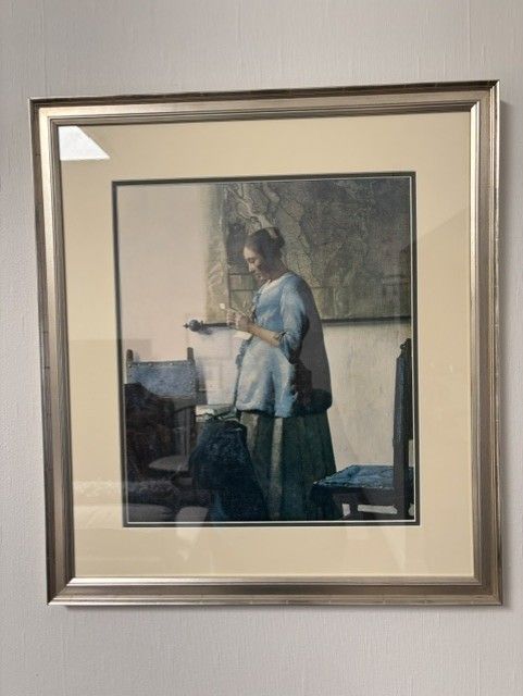 Framed reproduction of Johannes Vermeer's painting, "Woman Reading a Letter"