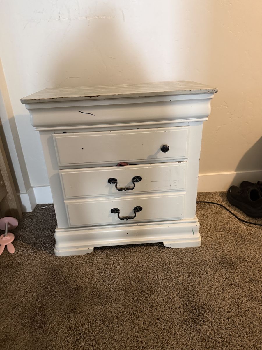 White Distressed Nightstand with Three Drawers and Wood-Tone Top