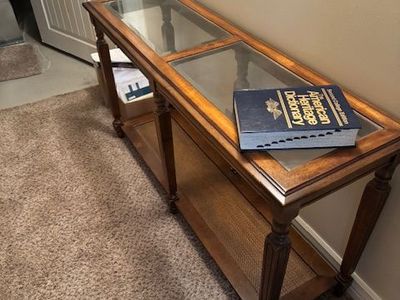 traditional glass-top console / sofa table with a lower shelf.