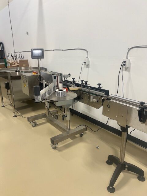 Sanitary conveyor - 15 feet long, accumulation table and labeler
