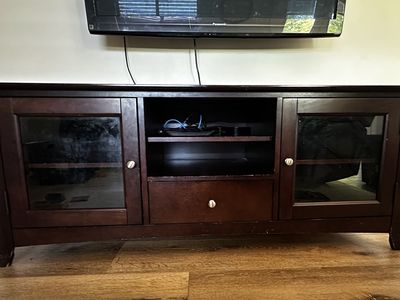 Dark wood tv stand with glass doors