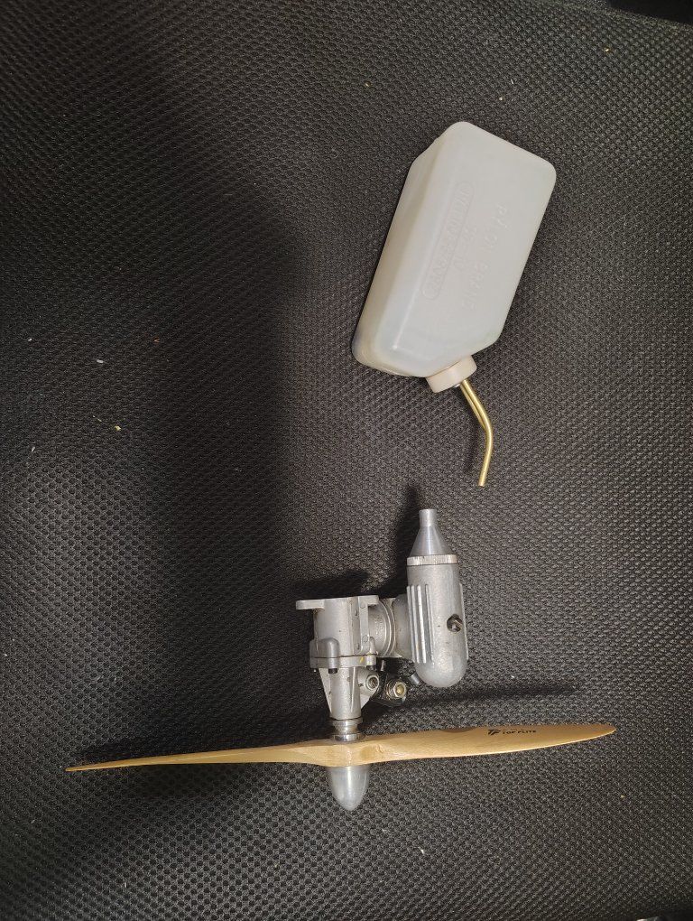 RC airplane nitro engine with exhaust, prop, and fule tank.