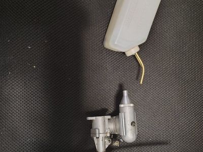 RC airplane nitro engine with exhaust, prop, and fule tank.