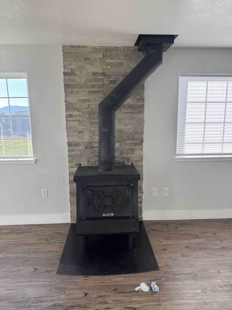 Used Wood Burning Stove with Metal Pipe and Hearth Pad