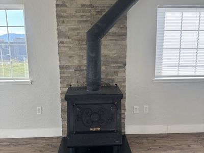 Used Wood Burning Stove with Metal Pipe and Hearth Pad