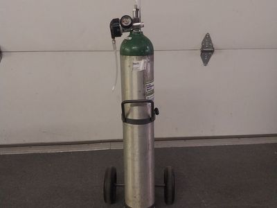 Medical-grade oxygen tank with cart and regulator.