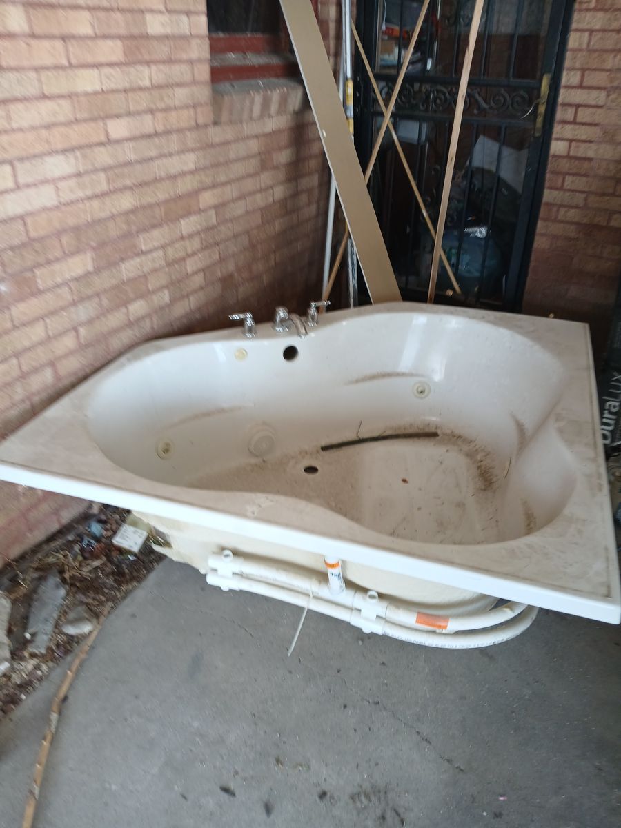 White Corner Jacuzzi Bathtub with Chrome Fixtures and Plumbing