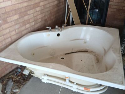 White Corner Jacuzzi Bathtub with Chrome Fixtures and Plumbing