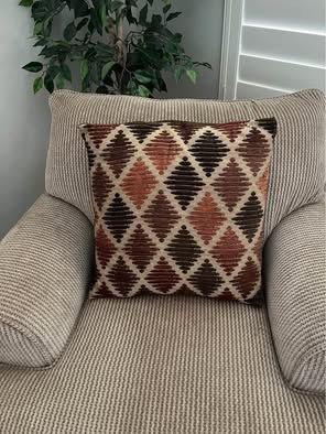 Two large 20 x 20 pillows in the colors of orange, brown and tan.