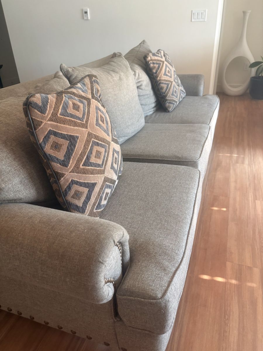 Gray Upholstered Sofa with Nailhead Trim and Patterned Throw Pillows