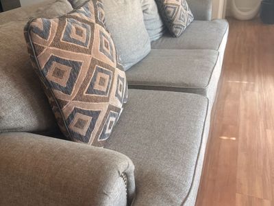 Gray Upholstered Sofa with Nailhead Trim and Patterned Throw Pillows