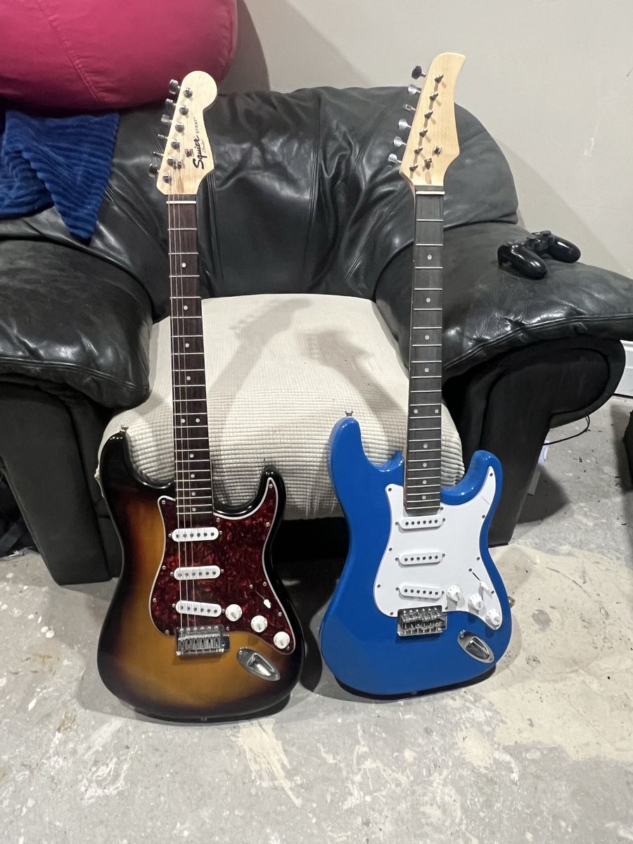 Two electric guitars and a box of strings