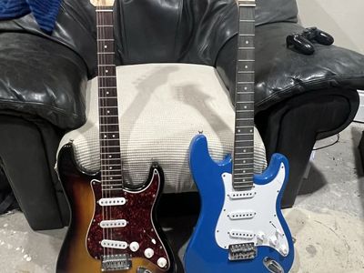 Two electric guitars and a box of strings