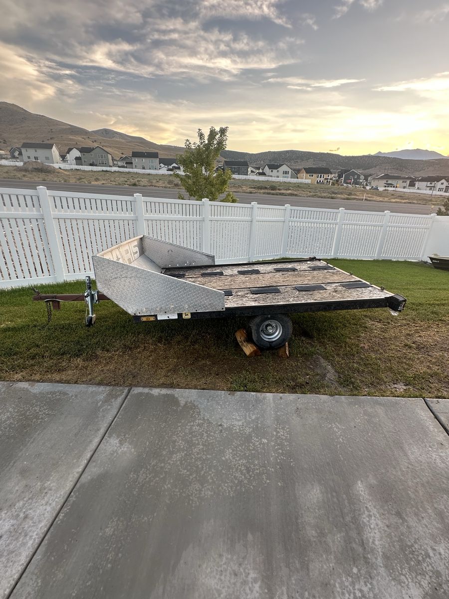 Tilt bed utility / snowmobile trailer.