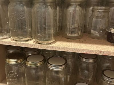 Dozens of assorted Mason jars, lids, and canning cooking pot.