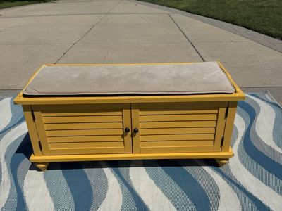 Yellow Storage Bench with Dual Cabinet Doors and Beige Cushion