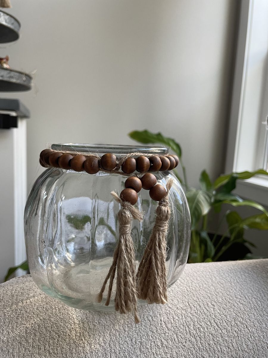 ribbed clear glass jar vase fall pumpkin with a wooden bead and jute tassel garland around the neck