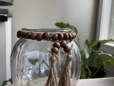 ribbed clear glass jar vase fall pumpkin with a wooden bead and jute tassel garland around the neck