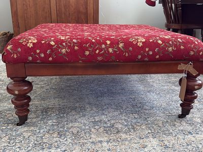 Antique Victorian era style ottoman on risers with cute spindle legs.