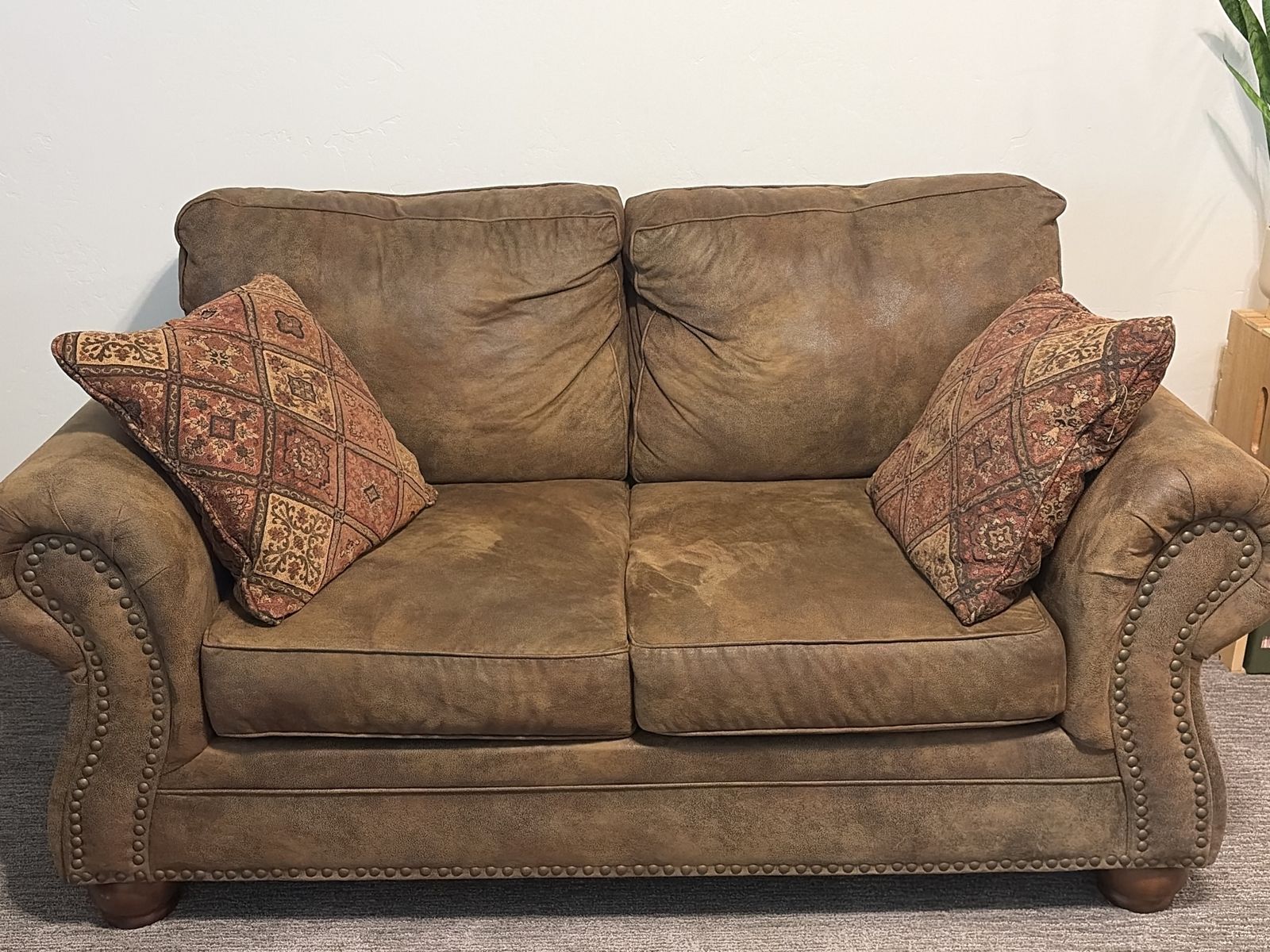 Brown Leather Loveseat and Chair with Nailhead Trim and Patterned Accent Pillows