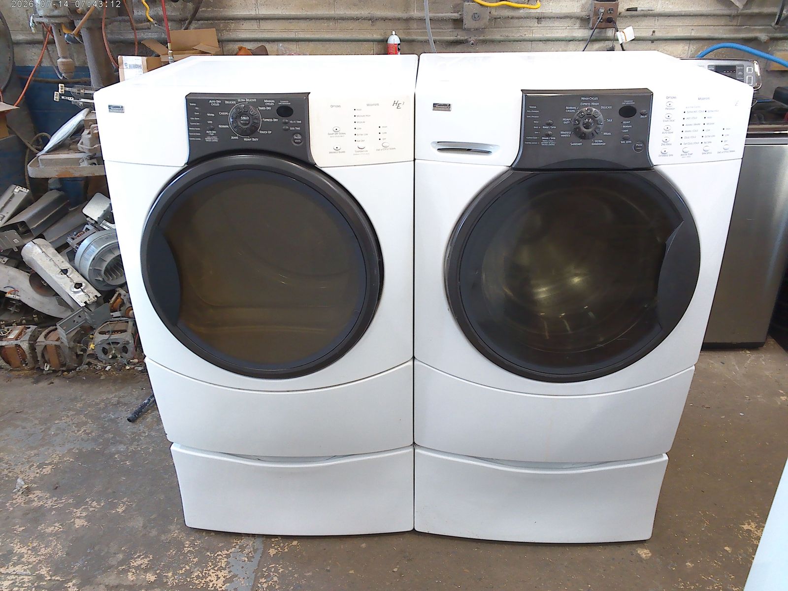 Kenmore Elite front load washer with matched electric dryer on pedestals