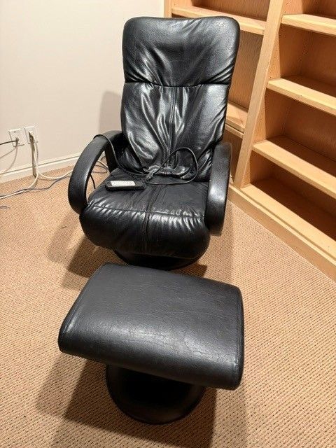 Black Leather Brookstone Stationary Massage chair with foot stool.