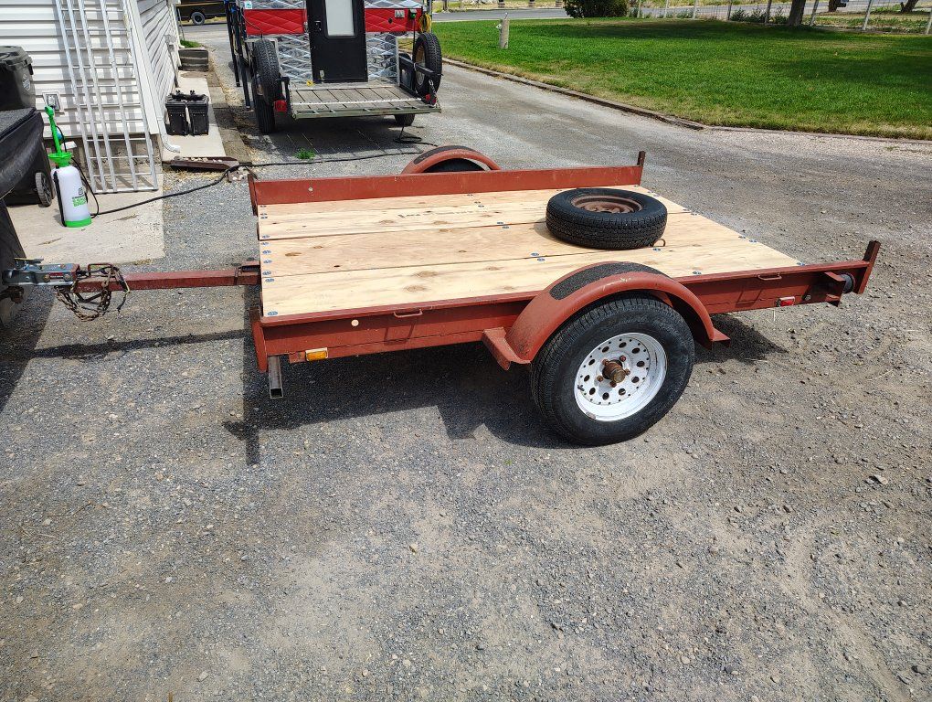 Red Utility Trailer - Flatbed, Single Axle and Spare Tire.