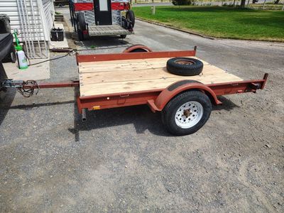 Red Utility Trailer - Flatbed, Single Axle and Spare Tire.
