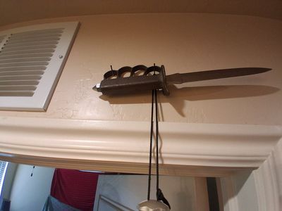 The item mounted on the wall is a U.S. Model 1918 Mark I Trench Knife. This iconic combat weapon was developed for hand-to-hand