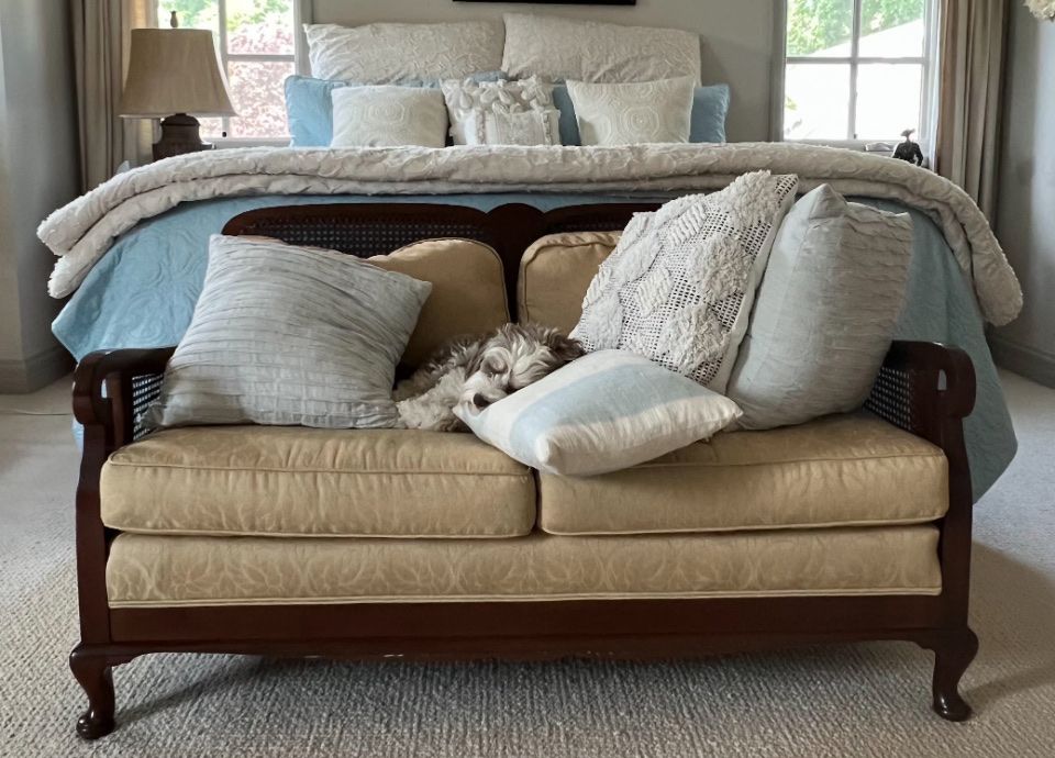Vintage Wooden Frame Loveseat with Tan Upholstery and Cane Details