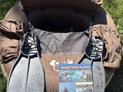 Float tube with flippers and book.