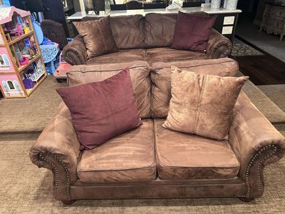 brown microfiber living room furniture set, featuring rolled arms with decorative nailhead trim and loose accent pillows.