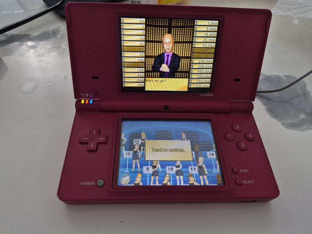 Nintendo DSi in hot pink,includes a proprietary charging adapter and 1 game