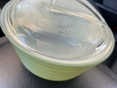 vintage green bowl appears to be a Jeannette Glass Jadeite Dripping Bowl, featuring a signature beehive-style ribbed design.