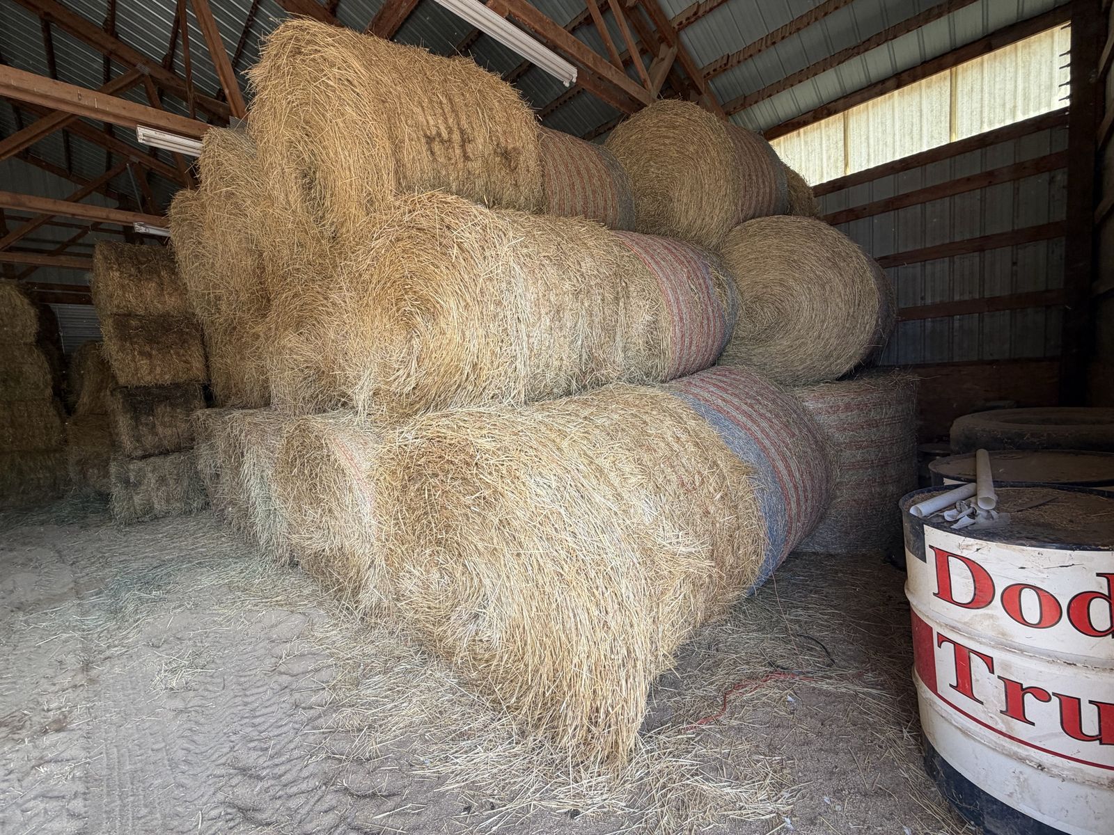 Large Round Grass Hay Bales Stored in Barn