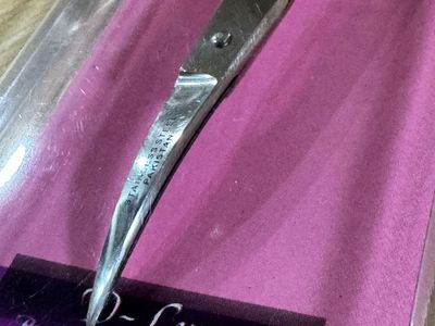A pair of D-Lux Precision Stainless Steel Scissors, featuring a specialized curved design. $11